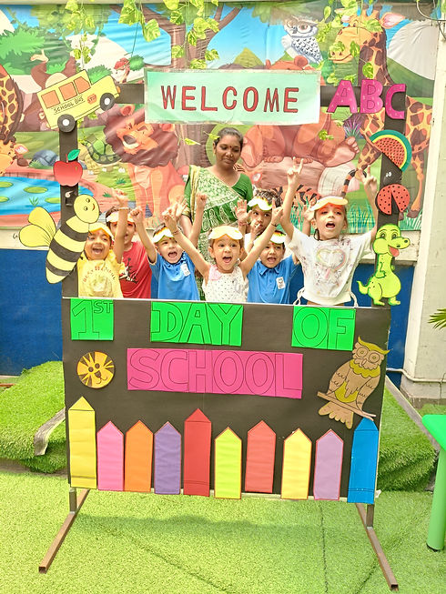 Excited preschool students celebrating their first day of school behind a colorful, handmade welcome frame at Trinity Pedagogy.