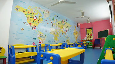 Modern Nursery classroom featuring educational world map murals and bright desks.