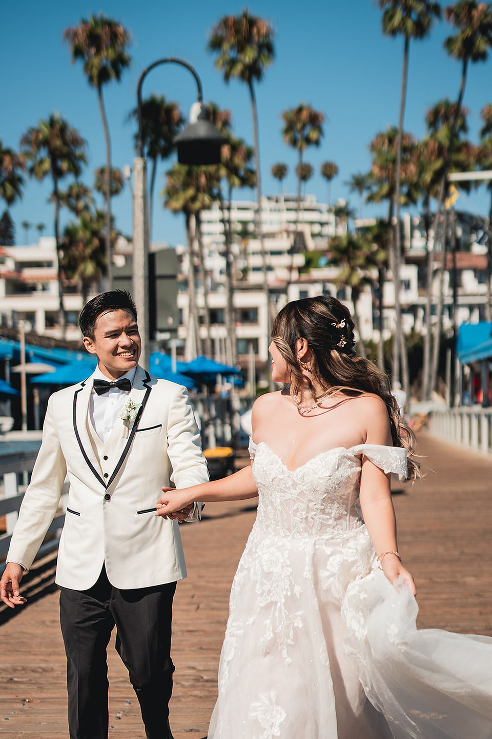 Newly weds walk the pier holding hands after their ceremony at Grey Museum shot by Alvis Pham Photography, Orange County California Wedding Photographer