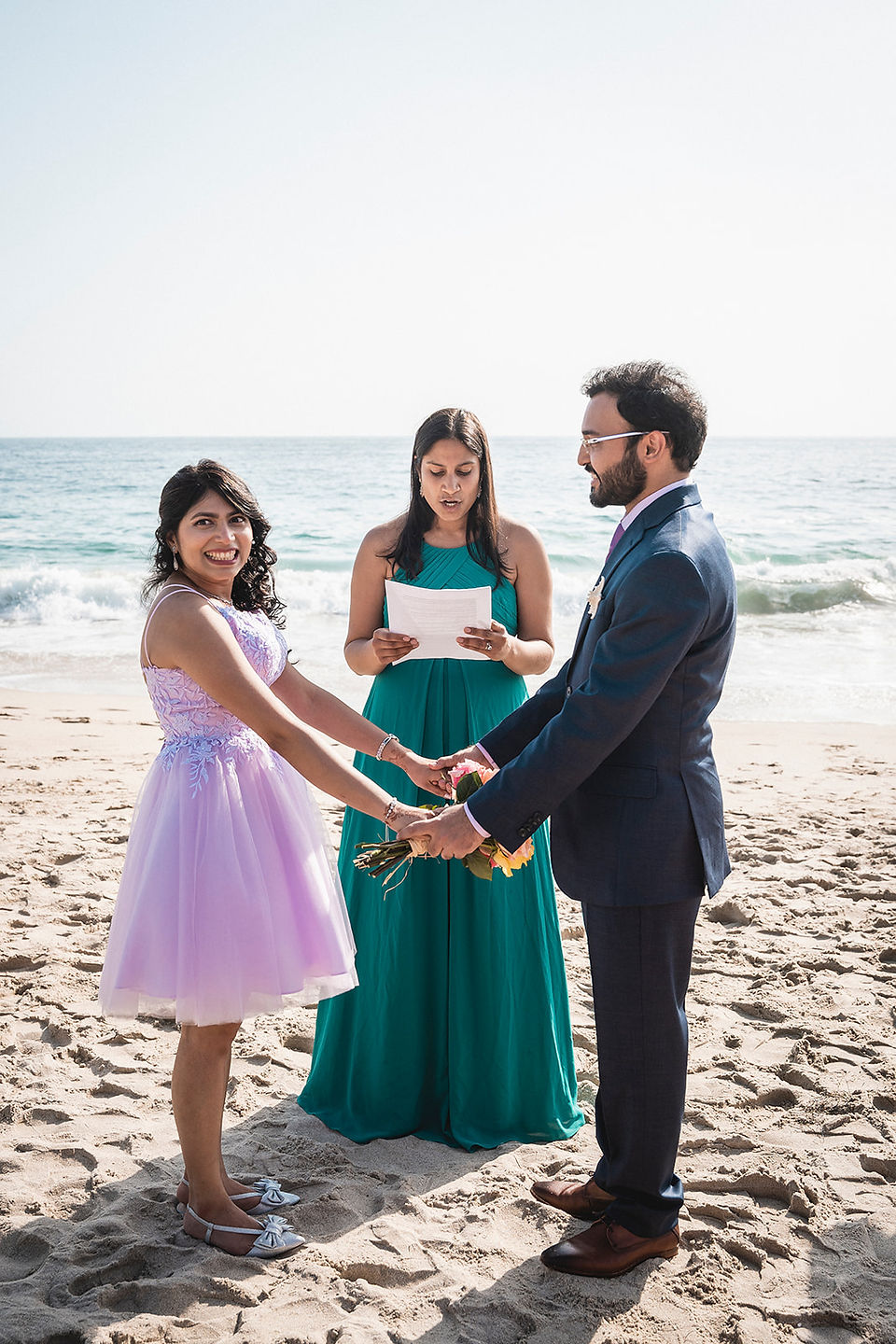 Couple holds hands during their ceremony at Victoria Beach in Laguna Beach shot by Paper Birch Collective, California Wedding Photographer and Videographer Team in Orange County