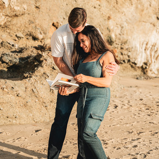 Couple looking at a scrapbook together during their Proposal shot by Paper Birch Collective, California Wedding Photographer and Videographer Team in Orange County