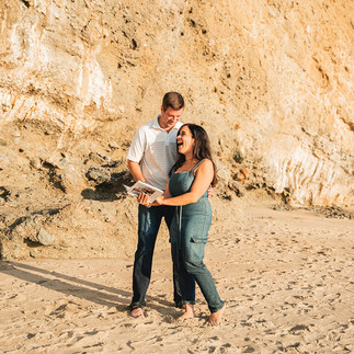 Couple laughs at a scrapbook during Proposal shot by Paper Birch Collective, California Wedding Photographer and Videographer Team in Orange County