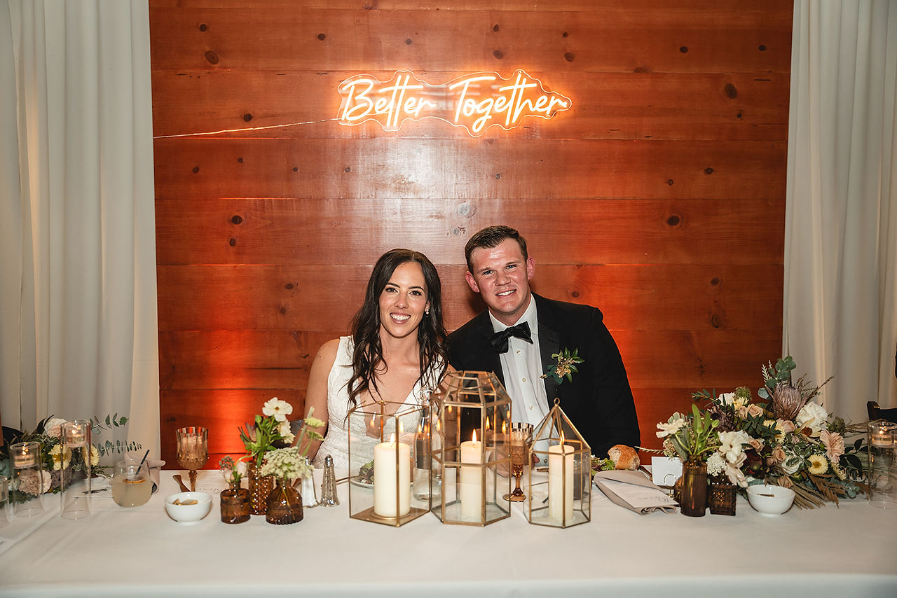 Newly weds sit together at The Barn at Aliso Viejo Ranch reception by Paper Birch Collective, California Wedding Photographer in Orange County