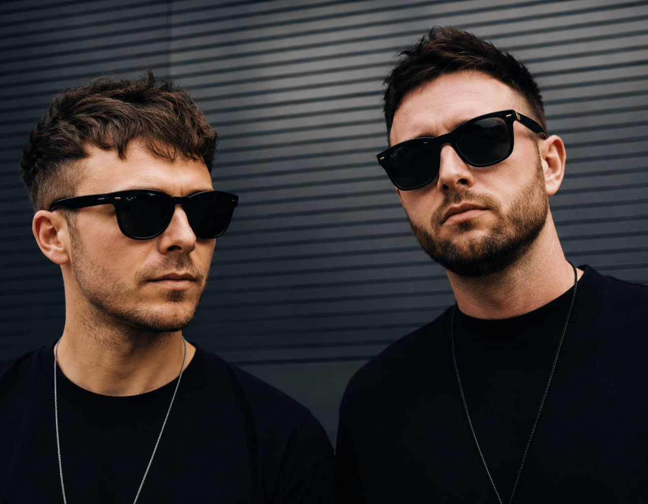 Members of Stereo Saints wearing sunglasses against a dark wall