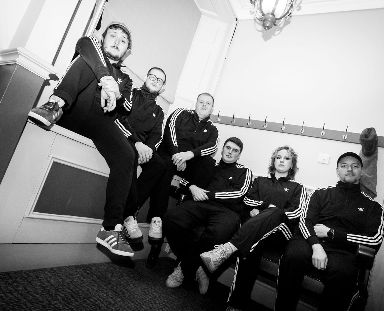 Members of Deltamanic posing in matching tracksuits.