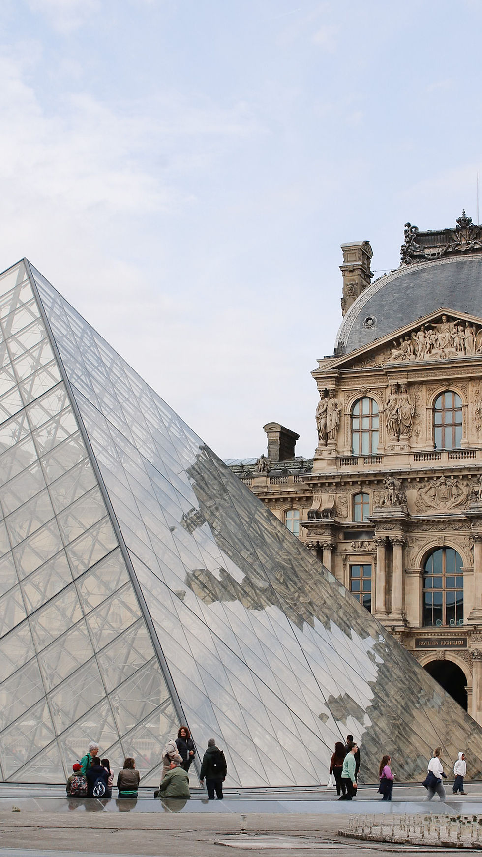 The Louvre Pyramid in Paris with visitors outside, symbolizing life in France for American expatriates