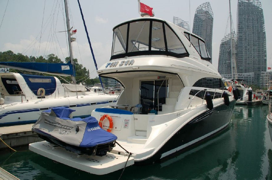 Luxury yacht docked at marina holding dinghy on sealift platform 