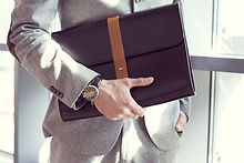 Businessman holding briefcase, close up