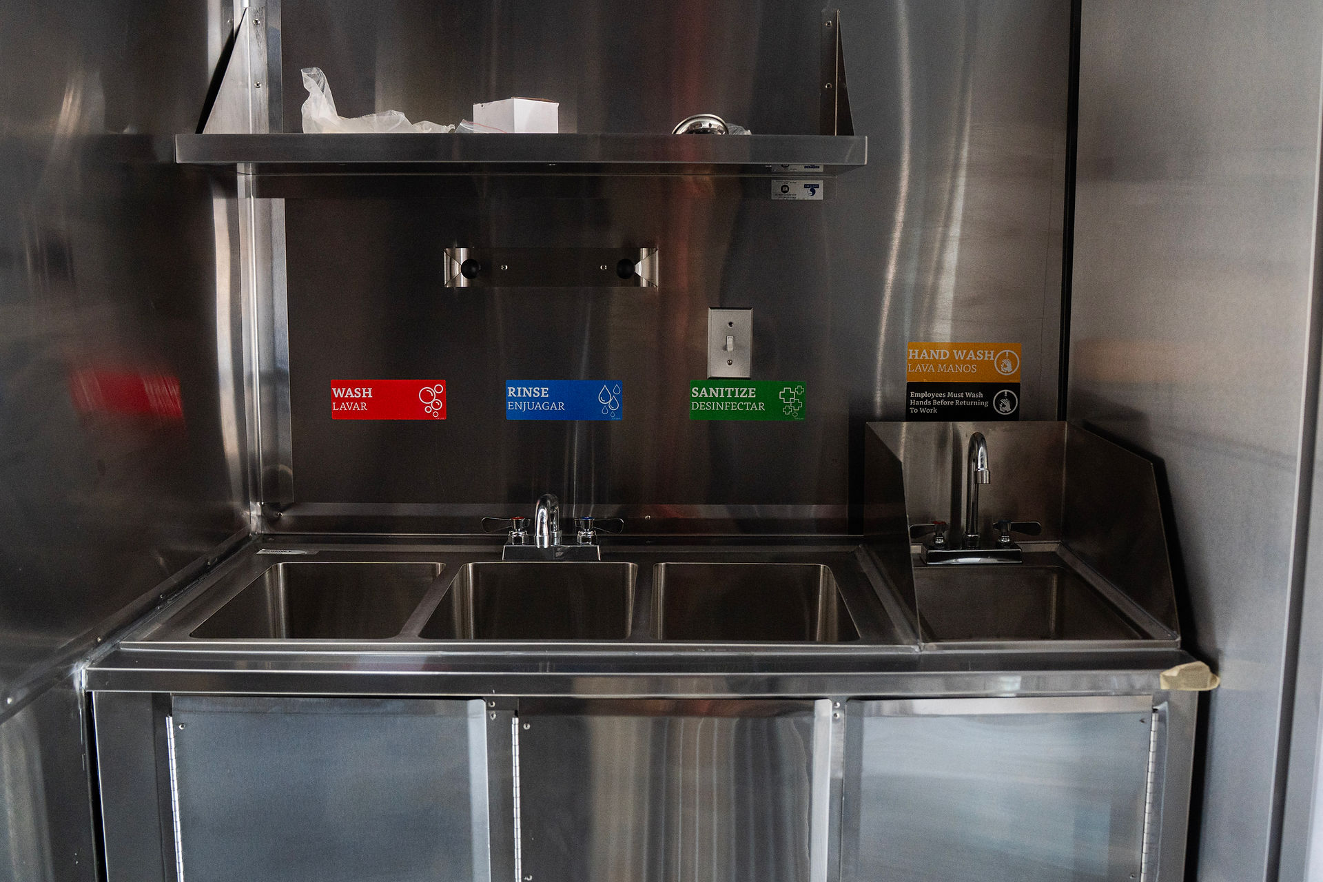 interior view of the 3-compartment sink and hand wash sink station with splash guards in the Jerk Truck.