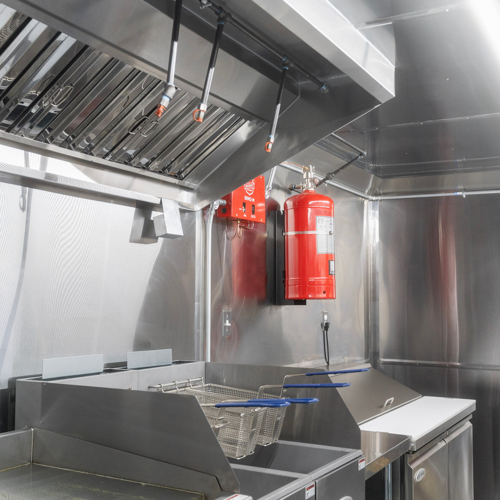 Commercial cooking line with high-output gas range and exhaust hood.