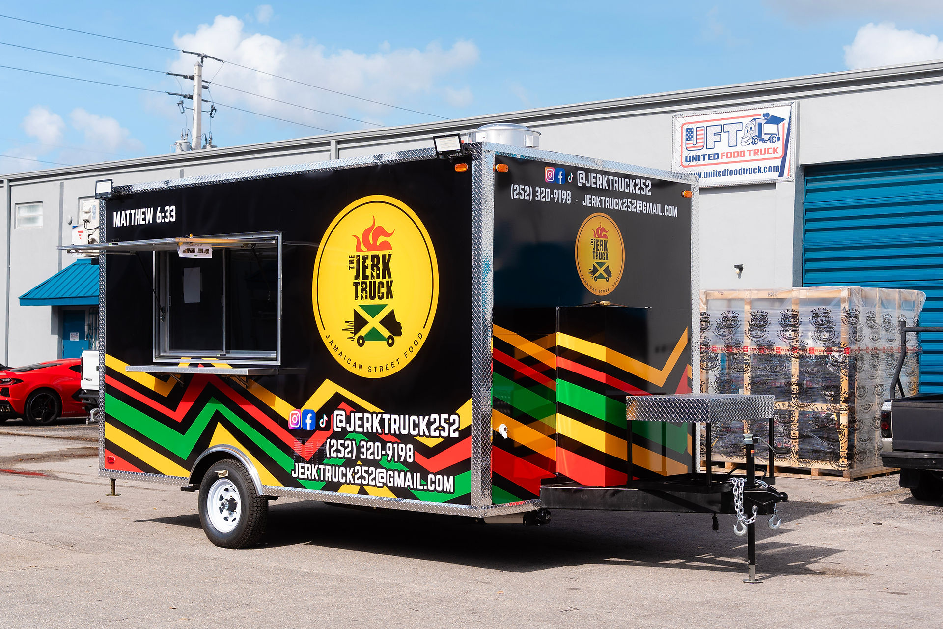 Full side view of the 14ft Jerk Truck concession trailer featuring vibrant Caribbean branding and contact information.