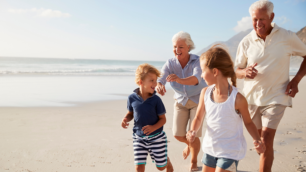 Grandparents running on the beach with their grandchildren.