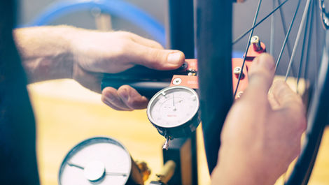 Mechaniker prüft Reifendruck mit Manometer