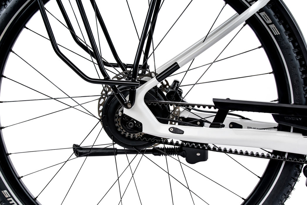 Hinterradansicht eines weißen Fahrrads mit Riemenantrieb und Gepäckträger