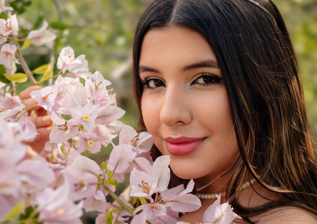 Retrato de quinceañera entre flores durante sesión fotográfica de quince años.
