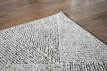 White and grey geometric rug on a wooden floor professionally cleaned by Allsmart