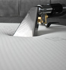 Close up shot of small carpet cleaning hand tool being used on a mattress