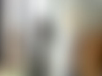 Smiling middle age business owner measuring cloth and cutting patterns in tailoring workshop