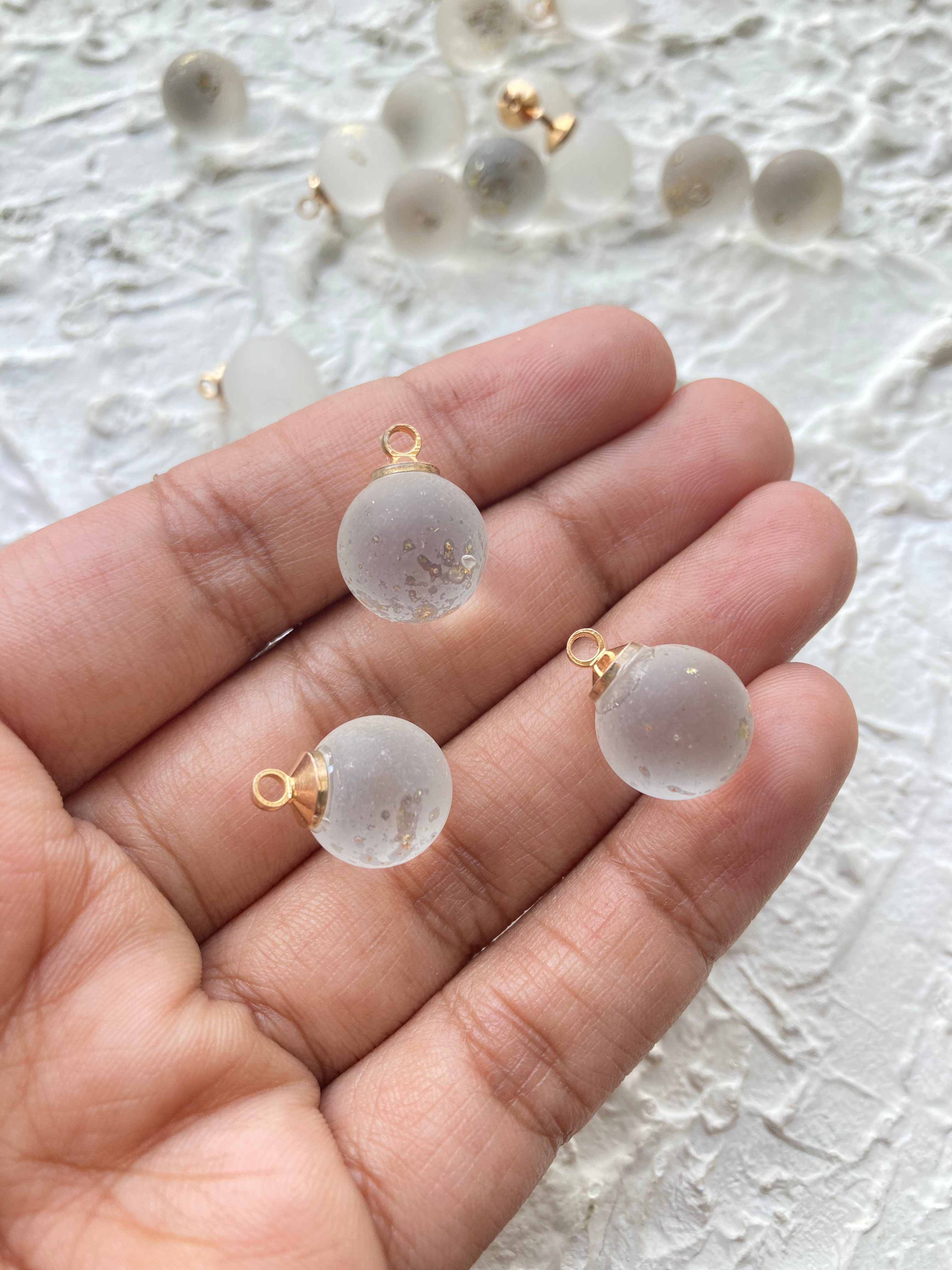 Frosted with golden hue round glass charm