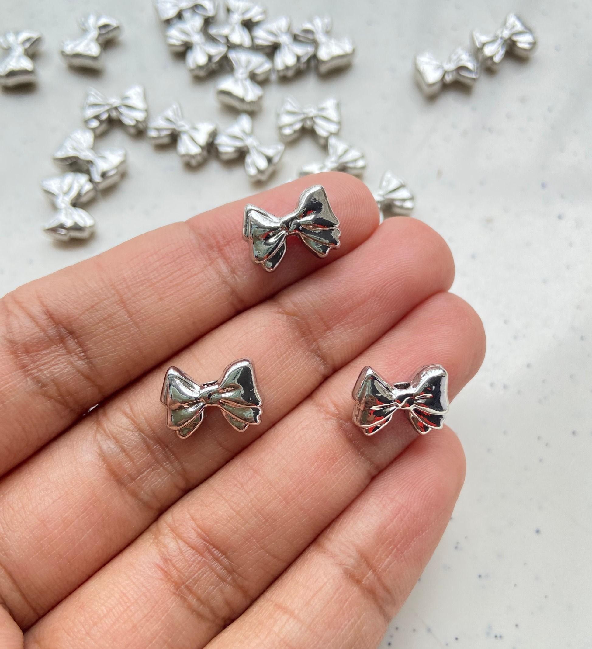 Alloy small bow shape bead, vertically drilled
