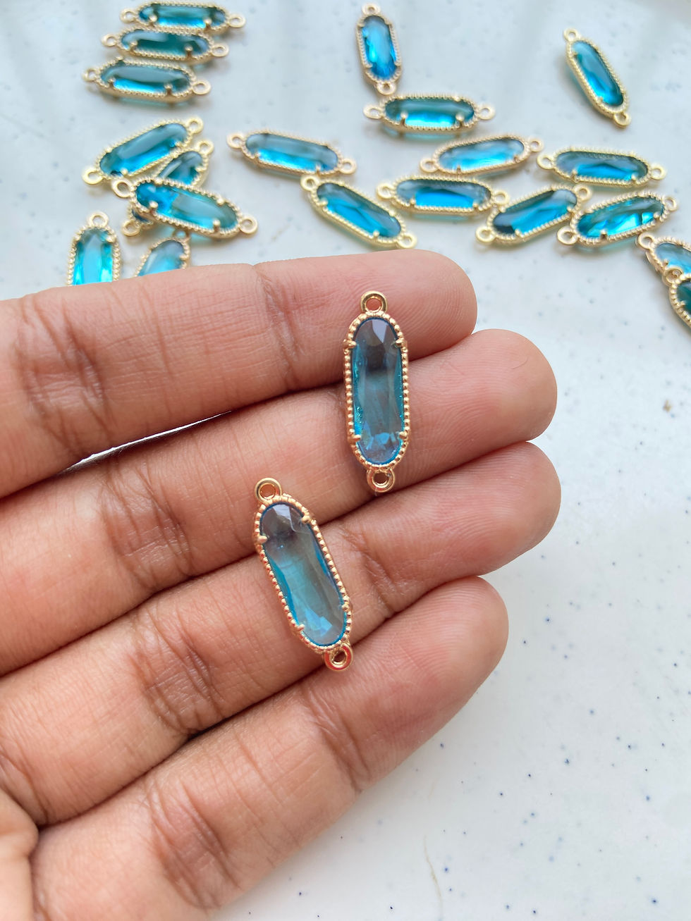 Thumbnail: Oval faceted glass connector with textured frame