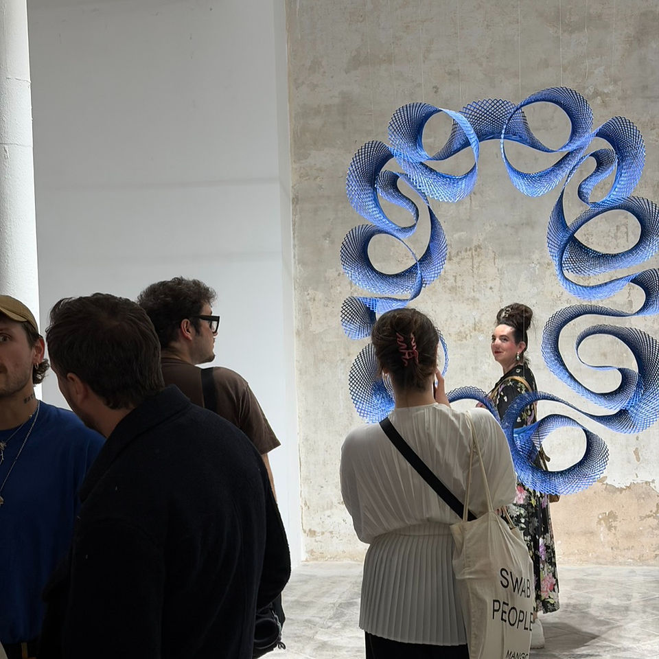 Visitors standing before Floating Court Reflections, experiencing the scale and shifting shadows of the bamboo installation.