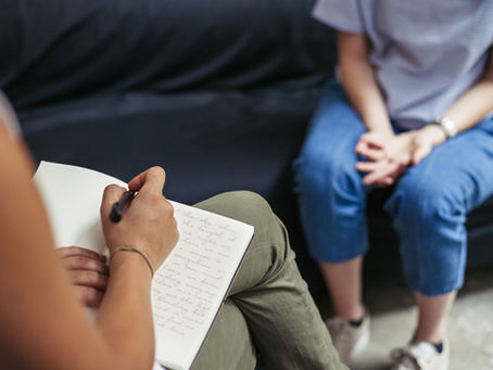 Person sitting in a therapist’s office, engaged in a supportive counseling session, with a calm and welcoming atmosphere.