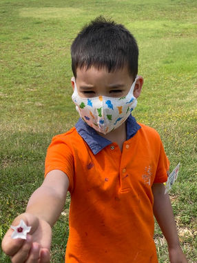 Preschool student holding a white flower