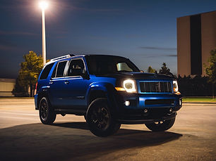 a dark blue SUV parked in a street light lit parking lot.jpg
