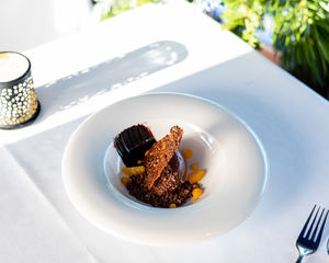 Dessert with chocolate and fruit on a white plate.