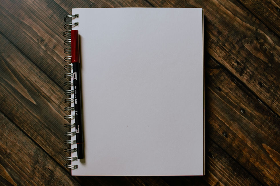 Blank spiral notebook with a black-and-red Tombow ABT 837 pen on a rustic wooden table, ready for writing.
