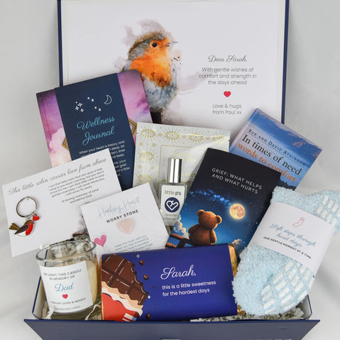 Sympathy gift box open showing a red robin on the inside lid and gift items in the bottom of the box. The items include a personalised candle, chocolate bar, socks, pillow spray, bereavement guide, red robin key ring