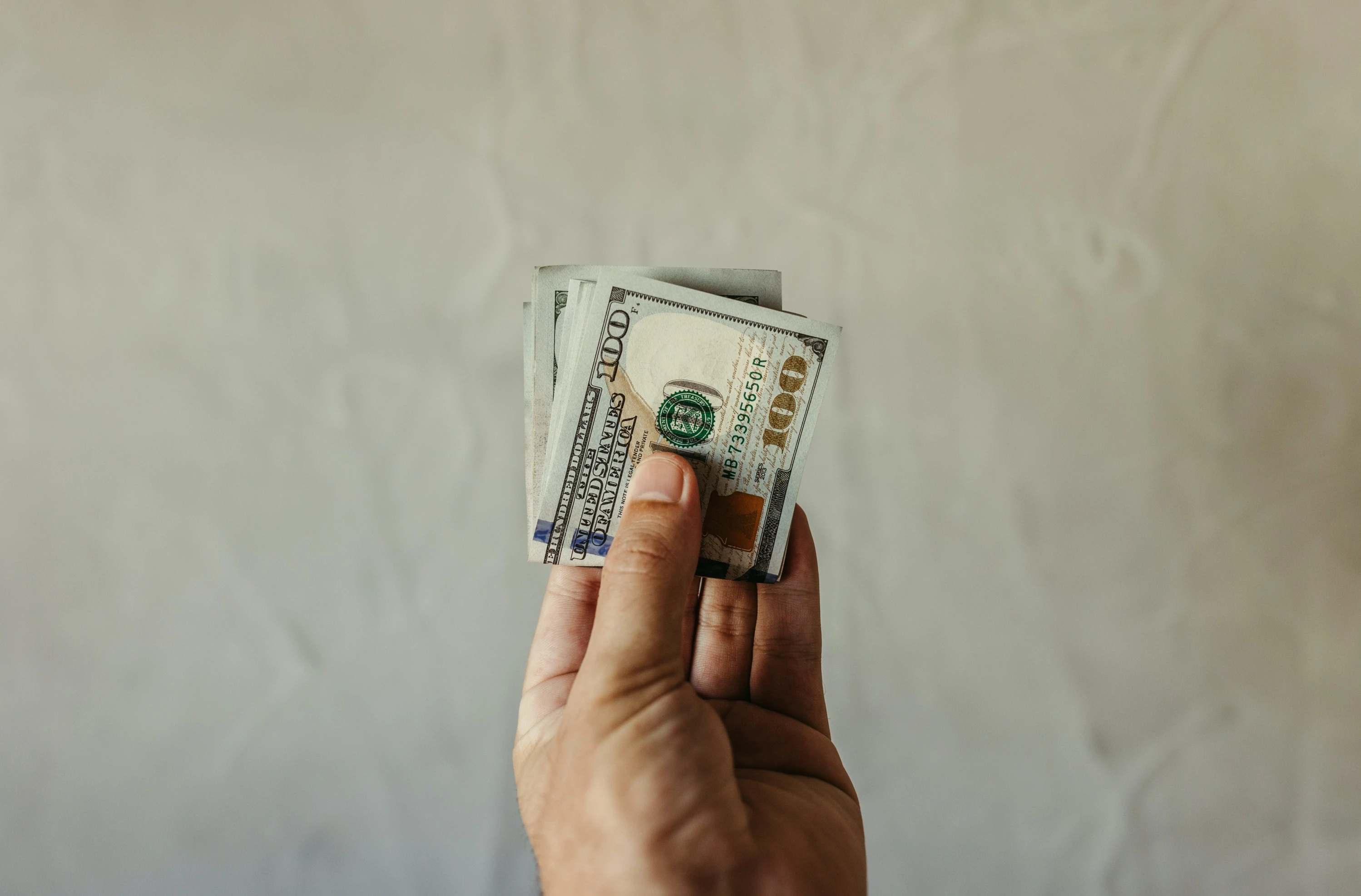a person holding a stack of money in their hand.webp