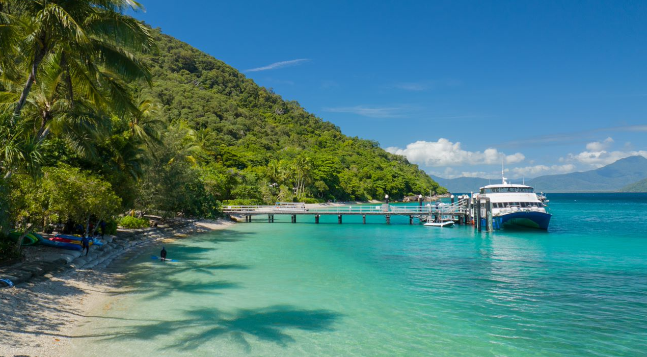 Tourist paddleboarding in clear blue lagoon at the reef.