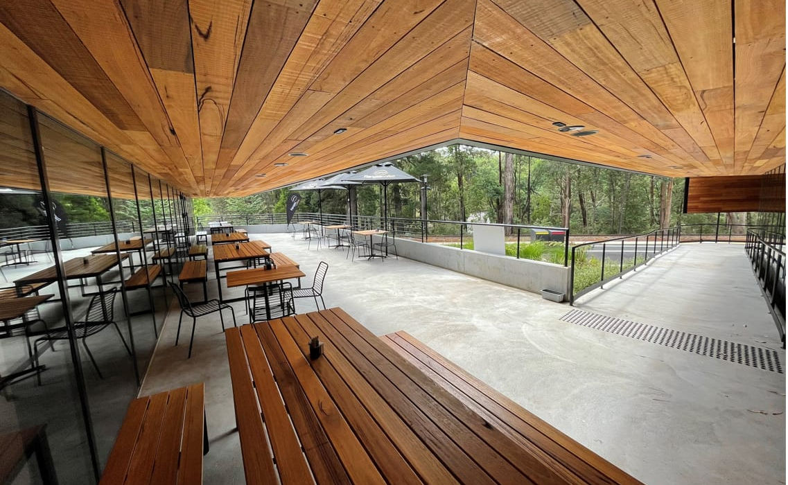 “Modern visitor center with timber interior and glass walls.”