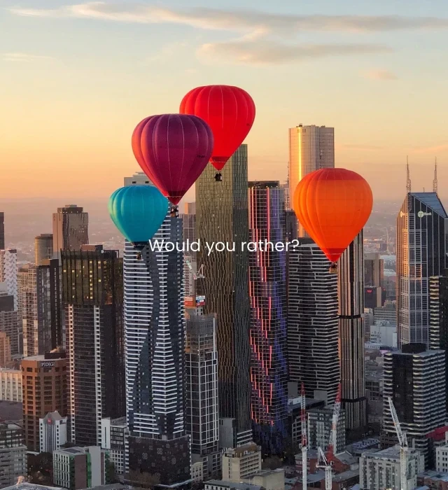 Hot air balloon rising over countryside during sunrise in Melbourne, Australia.