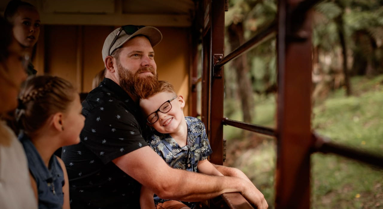 “Family smiling together while riding a heritage train.”