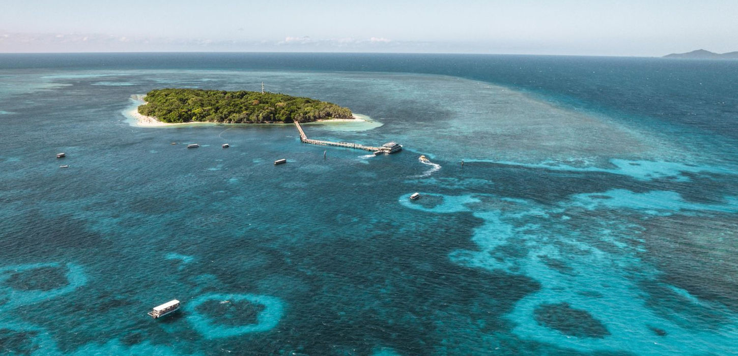 Glass-bottom boat sailing above coral gardens at Green Island Reef.