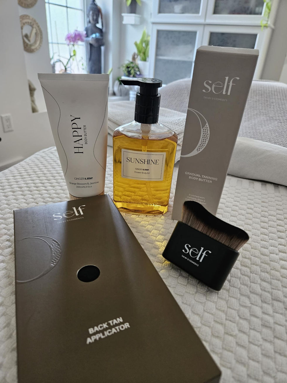Canadian self-tanning essentials available at Shoreline Glow in Kitchener-Waterloo, featuring SELF by O’Cosmedics and GINGER&ME body care products displayed on a spa bed.