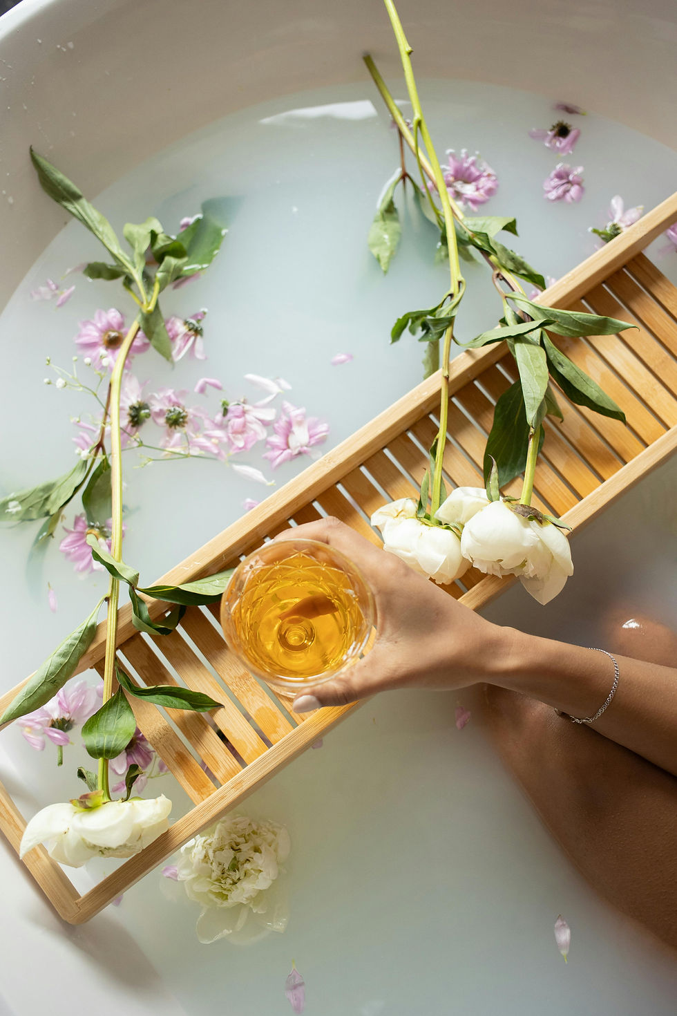 A woman holding a glass of wine in the bathtub