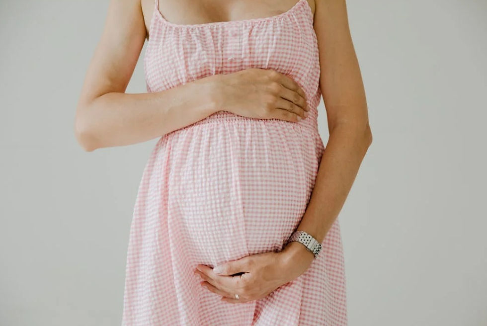 Close-up of a pregnant woman's belly, gently cradled by her hands, symbolizing nurturing, care, and the importance of safe skincare during pregnancy.