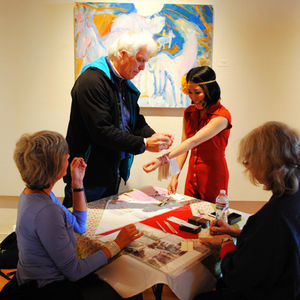 Mai Ryuno interacting with gallery visitors during c-o-n-n-e-c-t, exchanging cards and engaging in conversation.