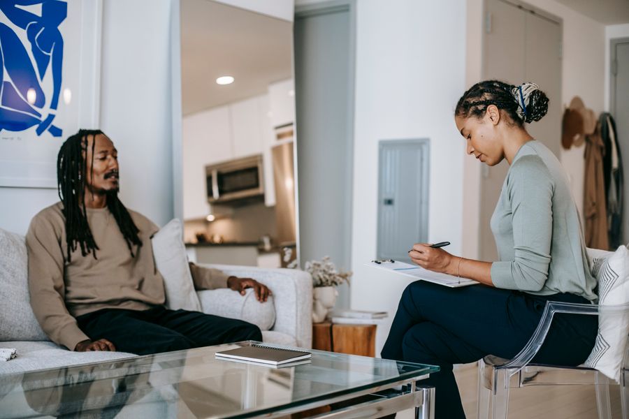 A Black man talks with a counselor in a calm, supportive session about healing and wholeness