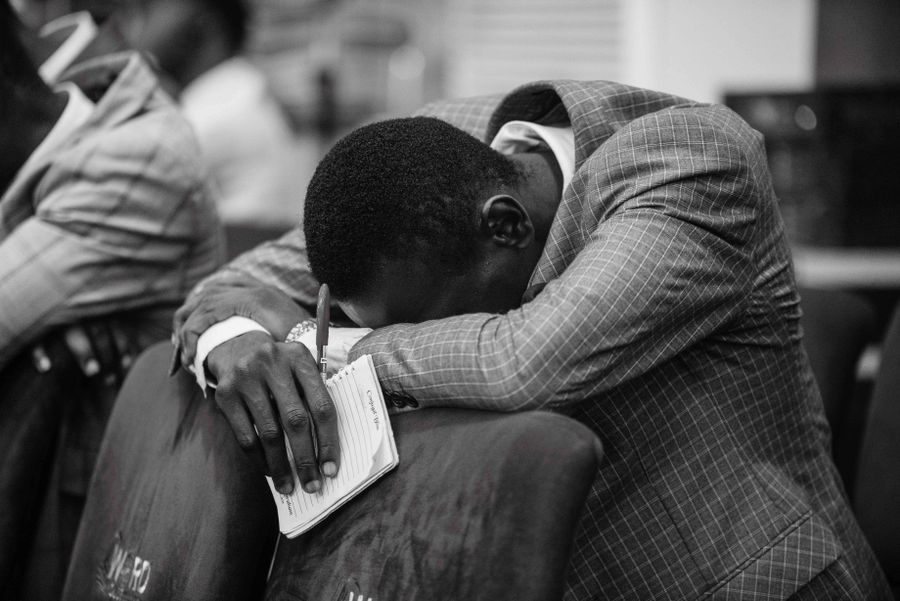 African American man in prayer and devotion during a church service