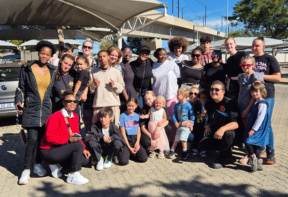 Children and adults from the Sinethemba Hope House family gathered together outdoors