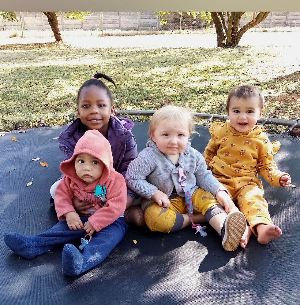 Four young children sitting together outdoors