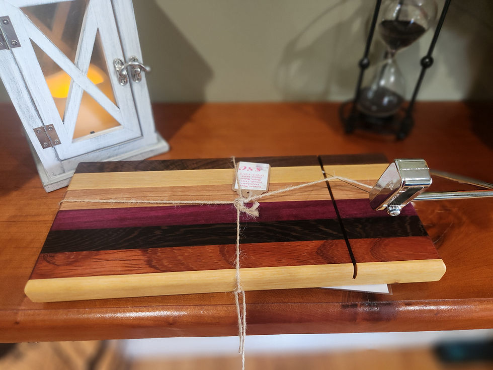 Colorful handcrafted hardwood cheese slicer standing upright, showing seven natural wood species and built-in metal slicing w