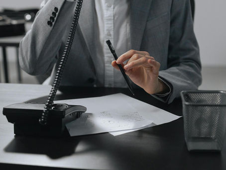 Funcionário em escritório atendendo ao telefone.