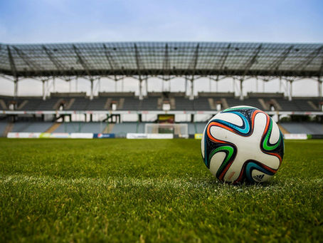 Bola de futebol na grama do campo.