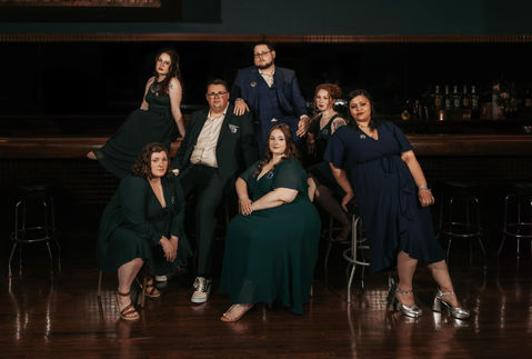 Wedding party posed in a moody bar setting at a Grand Rapids wedding reception.